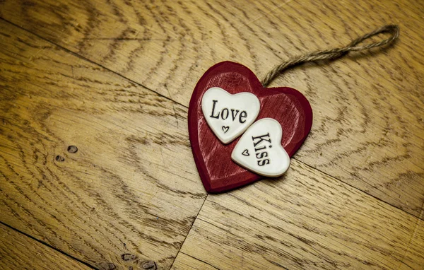 Corazón de amor rojo sobre fondo de textura de madera "love Kiss " — Foto de Stock