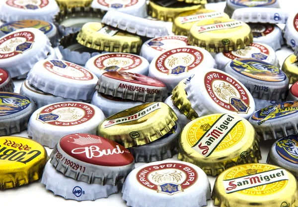 Pilha de tampas de garrafa usadas de cervejas sortidas — Fotografia de Stock
