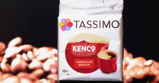 コーヒー豆の背景を持つタッシモコーヒーメーカーのための革命的なケンコアメリカの滑らかなコーヒーパック — ストック動画