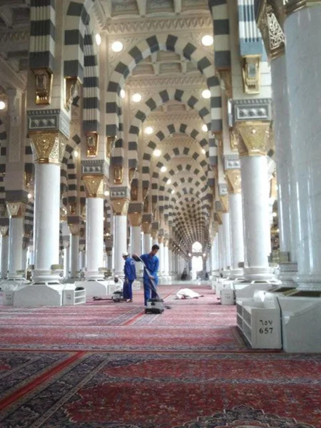 Deux travailleurs nettoient le tapis dans la mosquée Nabawi Photos De Stock Libres De Droits
