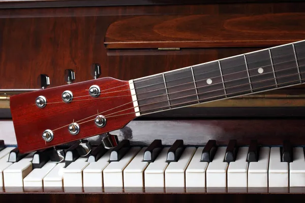Gitarrenhals auf alten Klaviertasten — Stockfoto