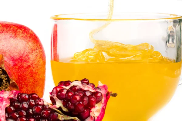 Pomegranate and honey flowing in a cup — Stock Photo, Image
