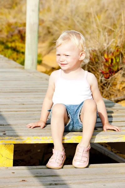 Little girl sitting on footbridge — Stock Photo, Image