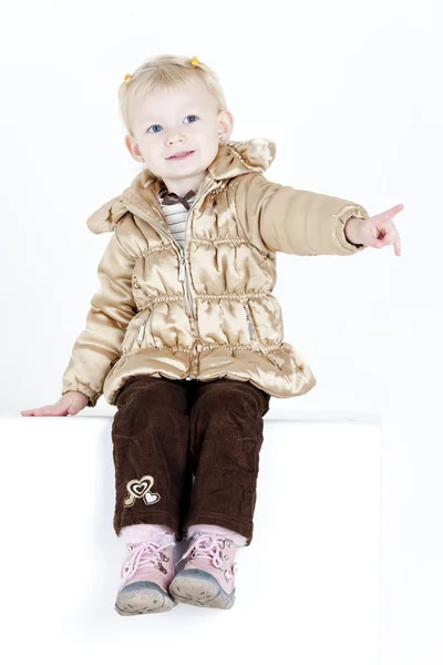 Sitting little girl wearing jacket — Stock Photo, Image