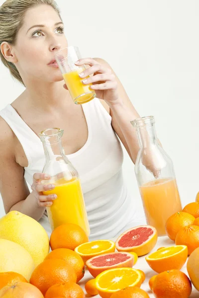Citrusfélék és a narancslé fiatal nő portréja — Stock Fotó