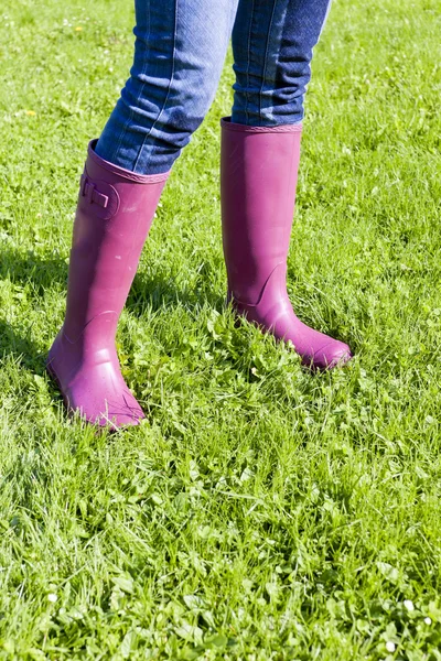 Détail de la femme portant des bottes en caoutchouc sur prairie de printemps — Photo