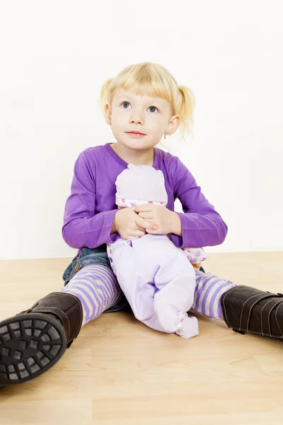 Kleines Mädchen spielt mit einer Puppe — Stockfoto