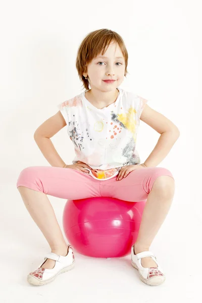 Meisje, zittend op een bal — Stockfoto