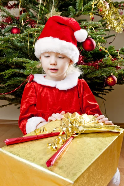 Klein meisje als santa claus met kerstcadeau — Stockfoto