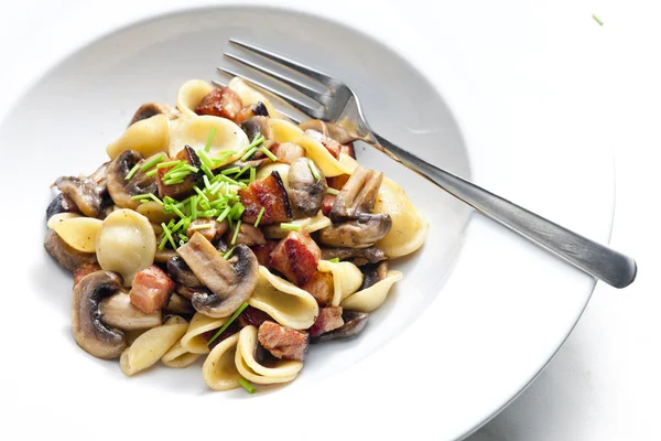 Pasta orecchiette with fried champignons and bacon — Stock Photo, Image