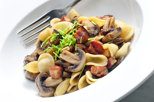 Pasta orecchiette met gebakken champignons en spek — Stockfoto