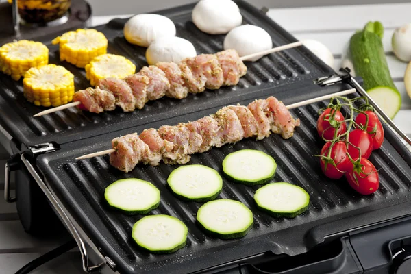 Meat skewers and vegetables on electric grill — Stock Photo, Image
