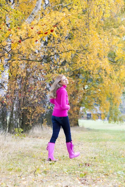 Kvinna som bär gummi stövlar i höstliga naturen — Stockfoto