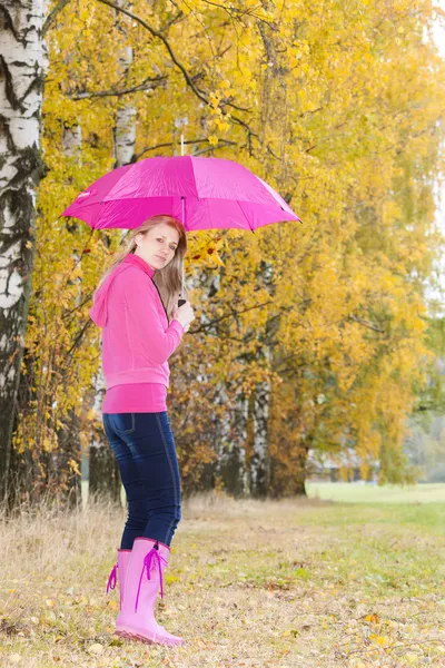 Femme portant des bottes en caoutchouc avec parapluie dans la nature automnale — Photo