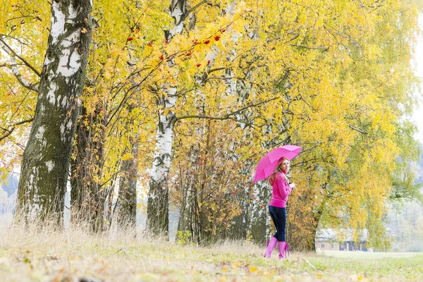 Mulher usando botas de borracha com guarda-chuva na natureza outonal — Fotografia de Stock