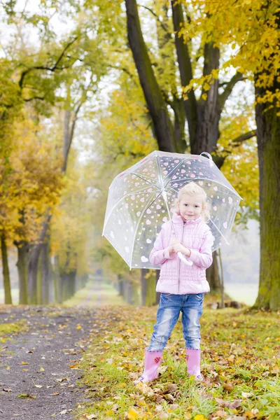 Klein meisje dragen van rubber laarzen in herfst steegje — Stockfoto