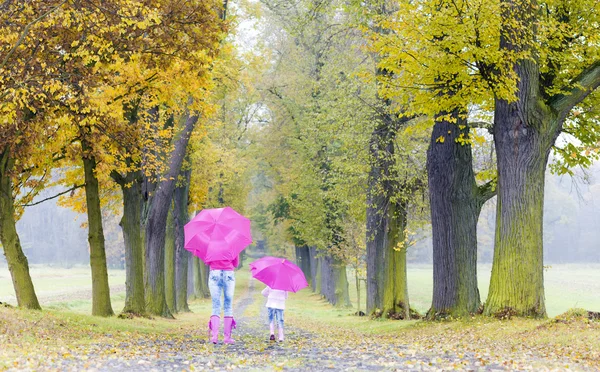 Anne ve kızı ile sonbahar sokakta şemsiye — Stok fotoğraf