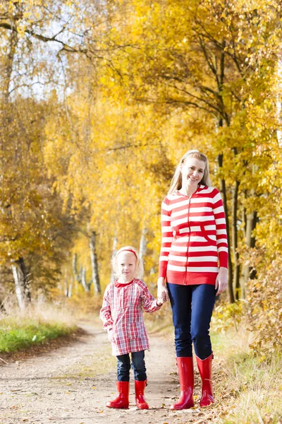 Mother with her daughter in autumnal alley — Stock Photo, Image