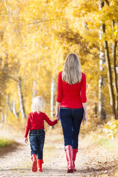 Mamma med sin dotter i höstlig gränd — Stockfoto