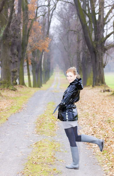 Frau trägt Gummistiefel in herbstlicher Gasse — Stockfoto