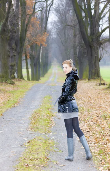 Frau trägt Gummistiefel in herbstlicher Gasse — Stockfoto