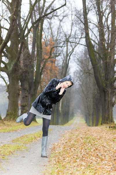 Frau trägt Gummistiefel in herbstlicher Gasse — Stockfoto