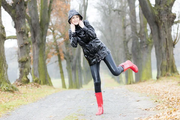 Γυναίκα που φοράει καουτσούκ μπότες σε φθινοπωρινό δρομάκι — Φωτογραφία Αρχείου
