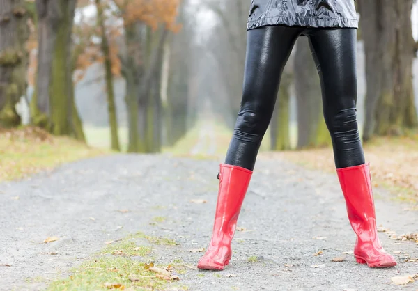 Femme portant des bottes en caoutchouc dans l'allée automnale — Photo