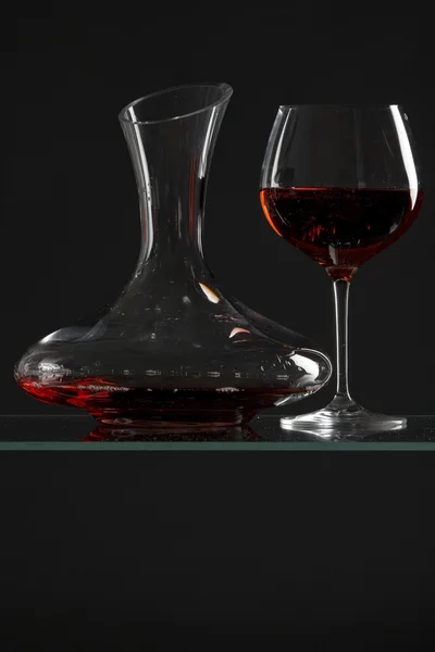 Decanter con vino rosso e vetro su un vecchio sfondo di pietra — Foto Stock