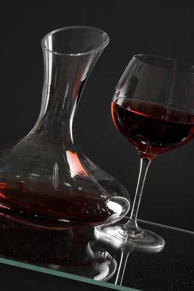 Decanter con vino rosso e vetro su un vecchio sfondo di pietra — Foto Stock