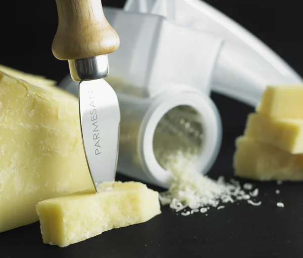 Queso parmesano provocativo y cuchillo sobre fondo blanco . —  Fotos de Stock