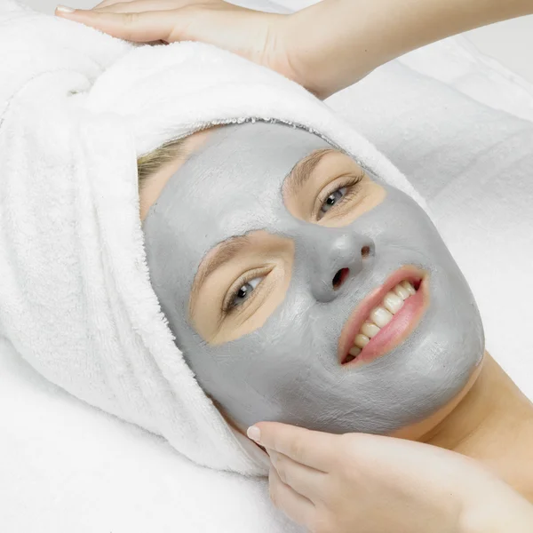 Aplicação de uma máscara cosmética na cara de mulher jovem no esteticista — Fotografia de Stock