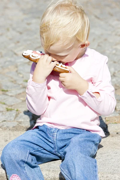 Portrait of little girl eating gingerbread — Stock Photo, Image