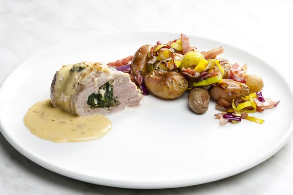 Baked pork tenderloin filled with spinach and goat cheese on cre — Stock Photo, Image