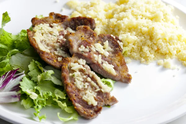 Collo di maiale alla griglia su aglio con couscous — Foto Stock