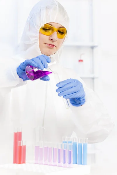 Jovem mulher vestindo casaco protetor em laboratório — Fotografia de Stock