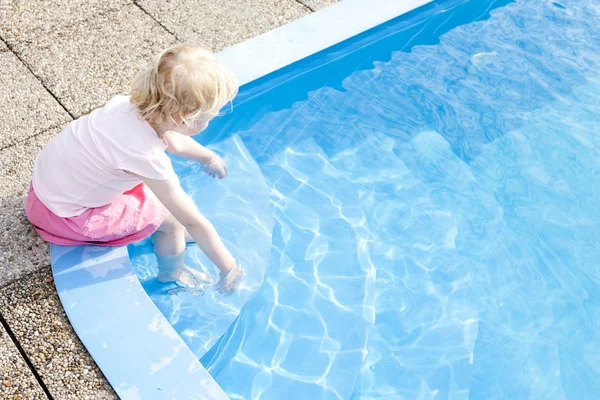 Petite fille assise près de la piscine — Photo