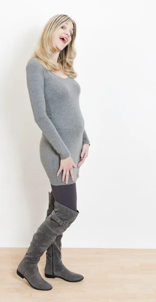 Standing pregnant woman wearing fashionable gray boots — Stock Photo, Image