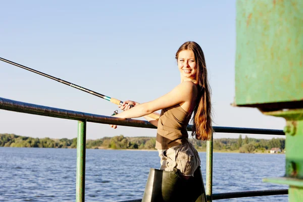 Mulher jovem pesca na lagoa — Fotografia de Stock