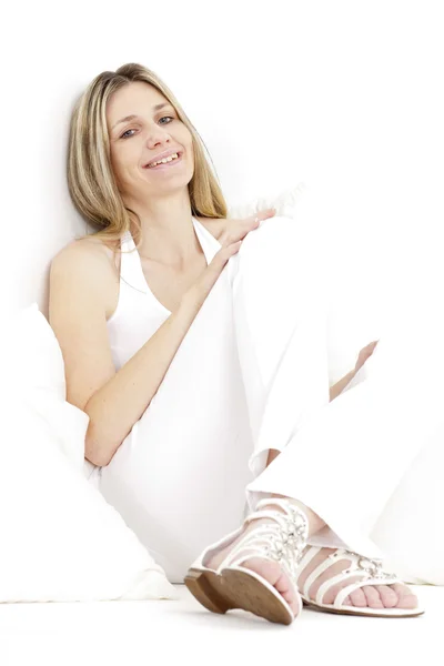 Porträt einer sitzenden Frau in weißen Kleidern und Sandalen — Stockfoto