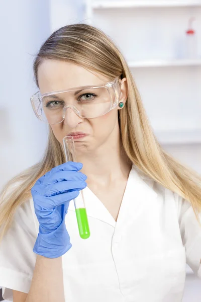 Mujer joven haciendo experimento en laboratorio —  Fotos de Stock