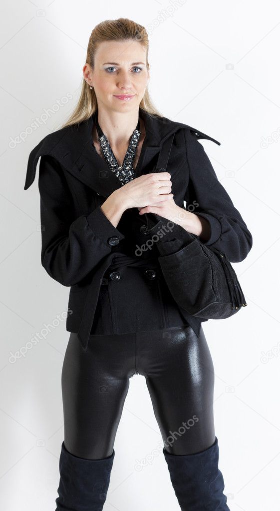portrait of standing woman wearing black clothes with a handbag