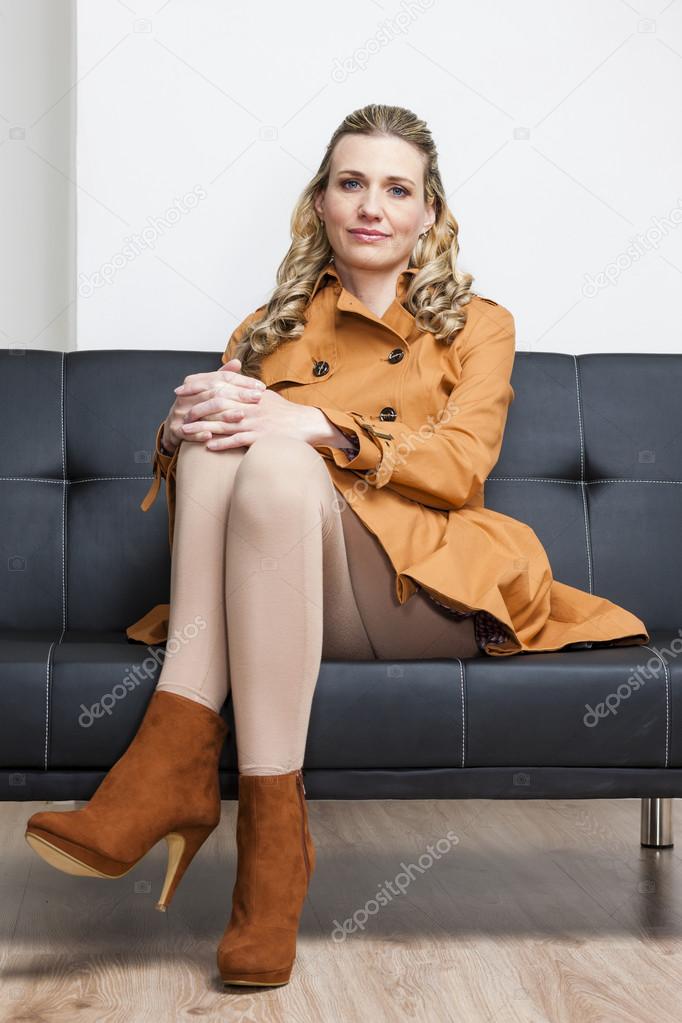 woman wearing brown coat sitting on sofa
