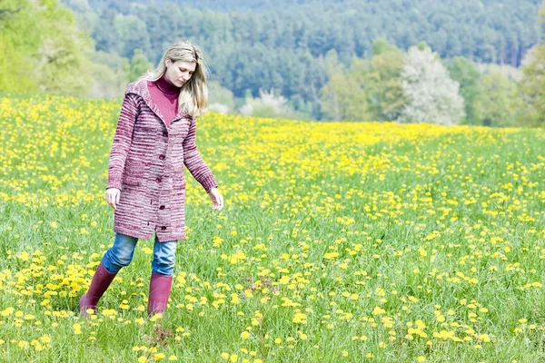 女性のゴムを着て春の牧草地に立っているをブーツします。 — ストック写真