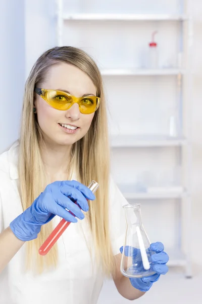 Mujer joven haciendo experimento en laboratorio —  Fotos de Stock