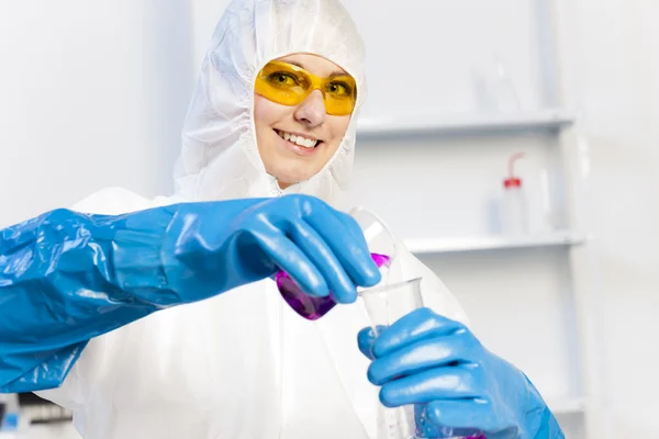 Młoda kobieta nosi płaszcz ochronny w laboratorium — Zdjęcie stockowe