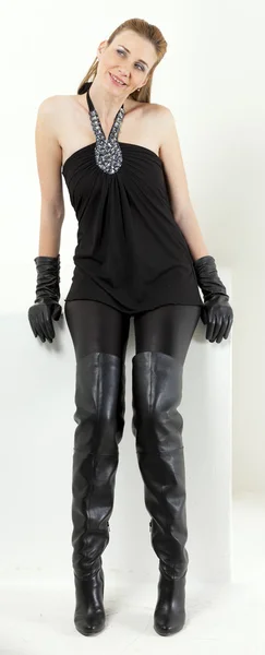 Sitzende Frau in schwarzer Kleidung und schwarzen Stiefeln — Stockfoto