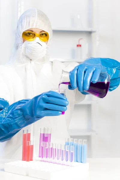 Jovem mulher vestindo casaco protetor em laboratório — Fotografia de Stock