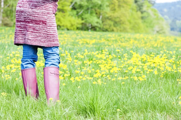 Detail of woman wearing rubber boots on spring meadow — Stock Photo, Image