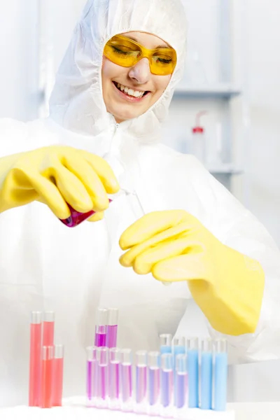 Mujer joven con abrigo protector en el laboratorio — Foto de Stock